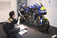 お気に入りの2004年型YZR-M1を撮影中の“もっちゃん”。展示物より、もっちゃんの動きを見るほうが面白かったとの説あり。 お気に入りの2004年型YZR-M1を撮影中の“もっちゃん”。展示物より、もっちゃんの動きを見るほうが面白かったとの説あり。