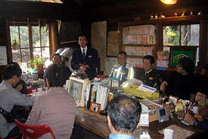 懇談会の冒頭で挨拶される左京警察署京北交番の所長。事故件数の推移、二輪の事故の特徴などを伺った。 懇談会の冒頭で挨拶される左京警察署京北交番の所長。事故件数の推移、二輪の事故の特徴などを伺った。